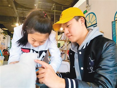 　　高士达(右一)觉得没有家人的陪伴，在海外留学时心里始终少了一些温暖。在家时，他希望自己可以多与家人相处，弥补在外留学的遗憾。图为他和妹妹在一起逗小猫。张馨予摄